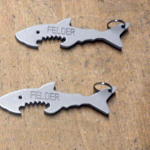 2 Flaschenöffner in Form eines Haifisches mit der Aufschrift FELDER