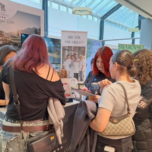 Schüler/innengruppe vor dem Stand des Interalpen Hotels