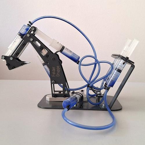 Model eines hydraulischen Baggers mit 4 medizinischen Spritzen mit Flüssigkeit und eines Baggerschaufel