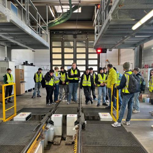 Bild zeigt eine Schülergruppe mit Warnwesten in einer Werkshalle der IVB