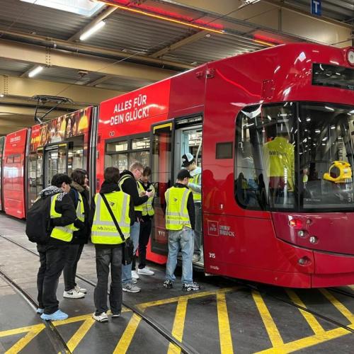 Bild zeigt eine Schülergruppe mit Warnwesten die in eine IVB Straßenbahn einsteigen