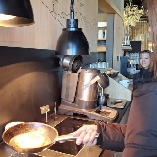 Bild zeigt eine Schülerin, die eine Pfanne mit einem Pancake hält