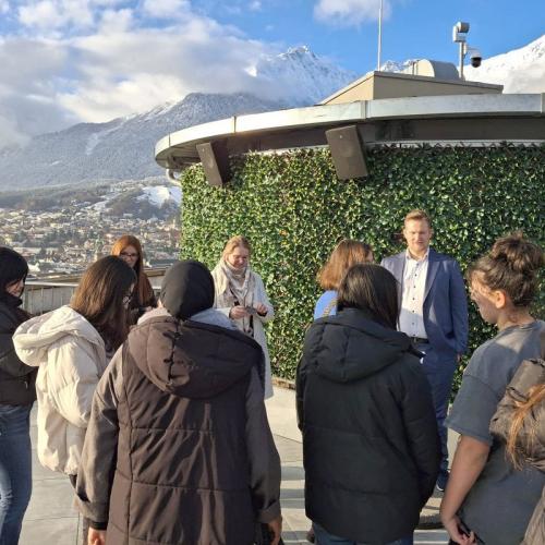 Schülerinnengruppe auf der Dachterasse des Hotel Adlers in Innsbruck im Hintergrund die verschneite Nordkette