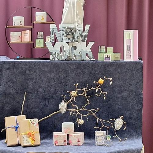 Das Bild zeigt einen Warentisch verschiedene Kosmektikprodukte sind mit weihnachtlicher Dekoration ansprechend über 2 Etagen aufgebaut.