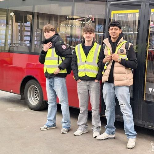 Bild zeigt drei Schüler vor einem Elektro-Bus der IVB