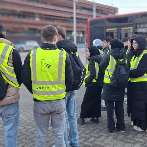 Bild zeigt mehrer Schüler*innen vor der Zentrale der IVB im Hintergrund ist noch ein IVB-Bus zu sehen