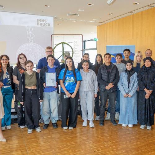Bild zeigt die Schüler/innen der Klasse B mit Landesräting Cornelia Hagele und Bürgermeister Johannes Anzengruber bei der Siegerehrung in der Stadtbibliothek Innsbruck bei der Verleihung des Kaiser-Maximilian-Preises 2026