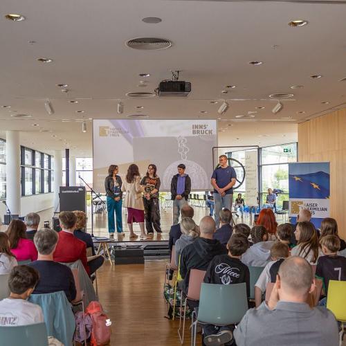 Bild zeigt die drei Schüler/innen der Klasse B mit Landesräting Cornelia Hagele  bei der Siegerehrung in der Stadtbibliothek Innsbruck bei der Verleihung des Kaiser-Maximilian-Preises 2026
