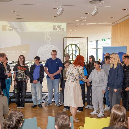 Bild zeigt die Schüler/innen der Klasse B mit Landesräting Cornelia Hagele und Bürgermeister Johannes Anzengruber bei der Siegerehrung in der Stadtbibliothek Innsbruck bei der Verleihung des Kaiser-Maximilian-Preises 2026