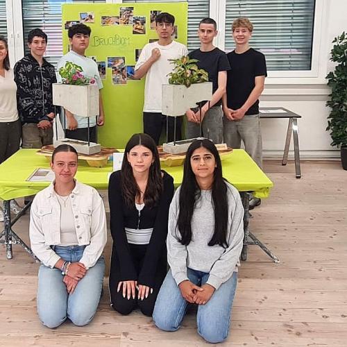Bild zeigt eine Gruppe von Schüler/innen beim Infostand der PTS Innsbruck mit dem Projektbeitrag Bruchbiom