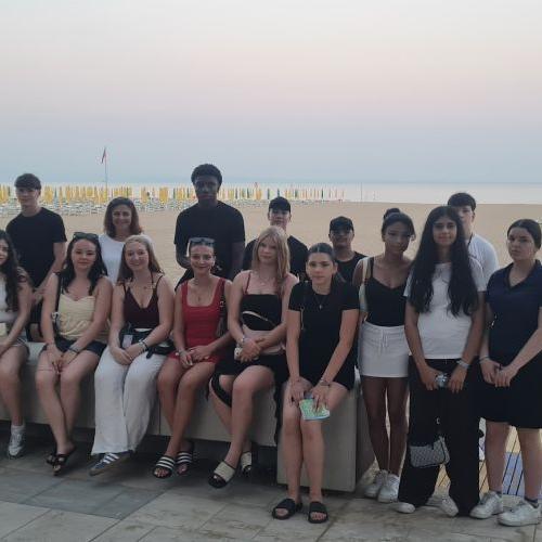 Bild zeigt eine Schüler*innengruppe im Hintergrund ist der Strand in Lignano und die Adria zu sehen