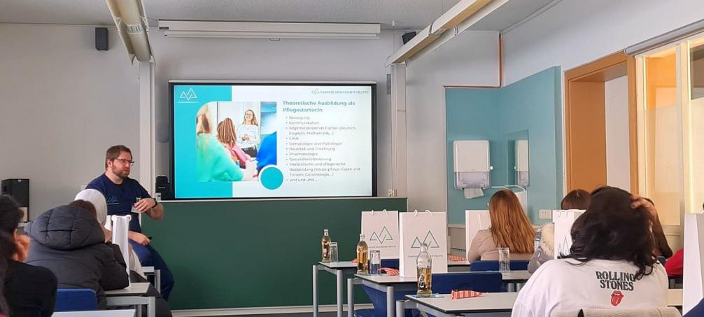 Bild zeigt einen Ausbilder des Pflegezentrums Reutte eim Vortrag über das Pflegzentrum im Vordergrund Schülerinnen der Pflegegruppe der PTS Innsbruck