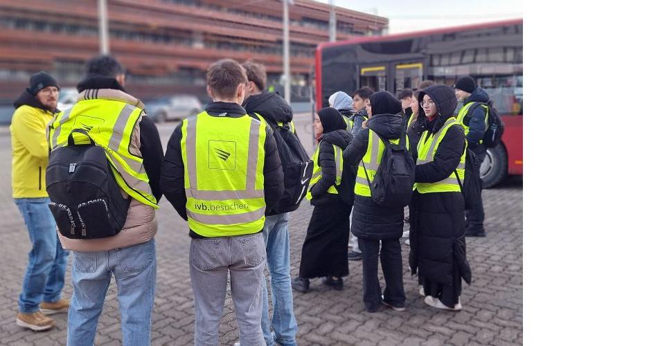 Bild zeigt Schüler*innengruppe vor der Zentrale der IVB im Hintergrund ist ein IVB-Bus zu sehen