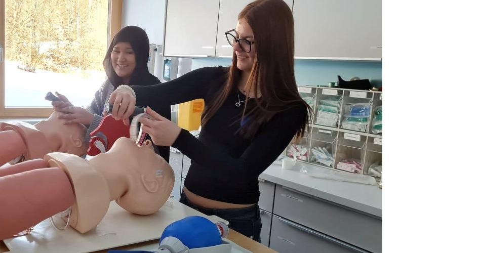 Bild zeigt zwei Schülerinnen an Pflegeübungspuppen