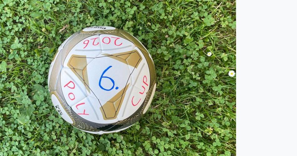 Bild zeigt einen Fußball auf grünem Rasen liegend mit der Aufschrift Poly-Cup 2026 in den Farben weiß und gold