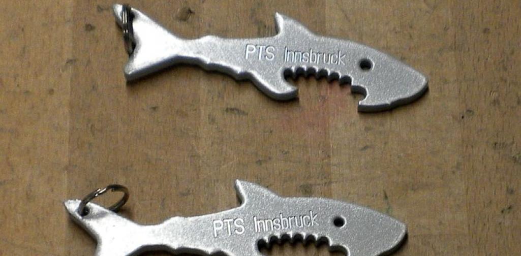Metall_6_25 Bild zeigt 4 Schlüsselanhänder stylisierter Haifisch mit Aufschrift PTS
