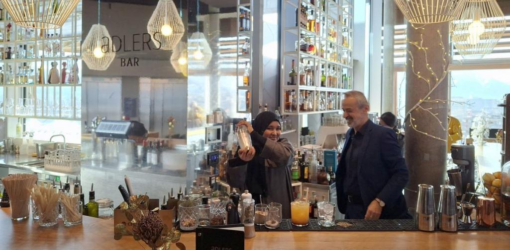 Bild zeigt eine Hotelbar ein Barkeeper mixt Getränke mit einer Schülerin