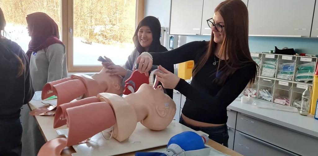 Bild zeigt zwei Schülerinnen der Pflegegruppe mit zwei Pflegepuppen